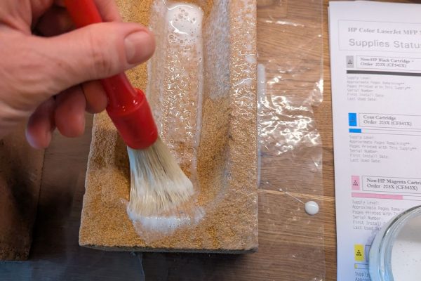 Brushing on the glue to cover the brick.