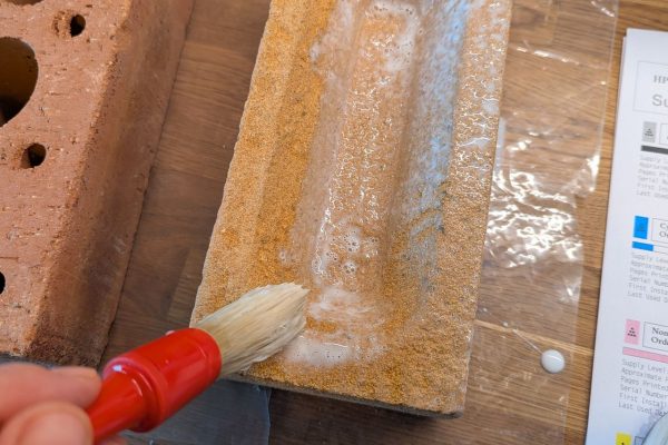 Brushing on the glue to cover the brick.