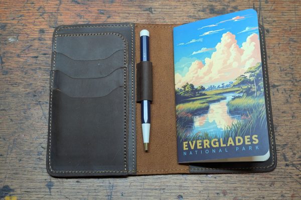Leather journal cover, with a notebook and pen.