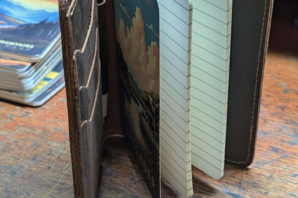 Leather journal cover, with a notebook and pen.