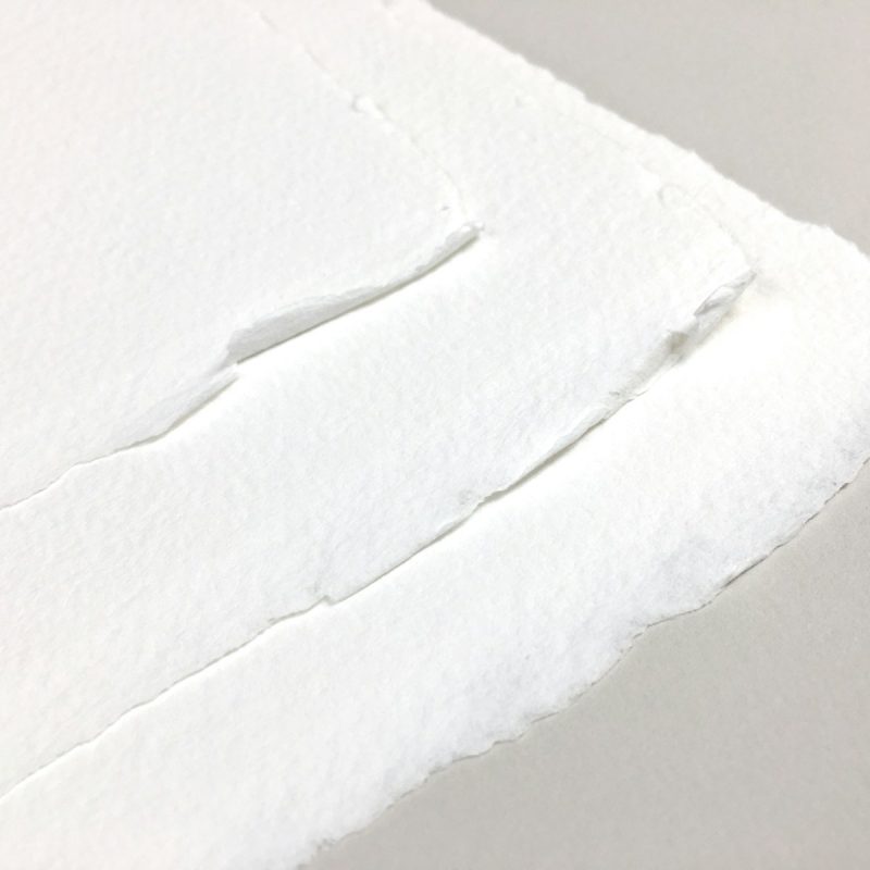 a piece of white paper with a hole in it