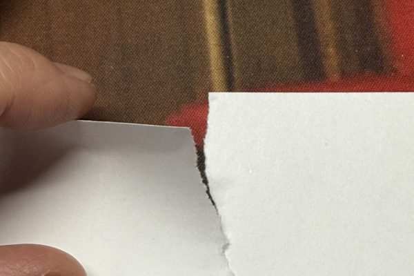 Tearing paper along its grain.