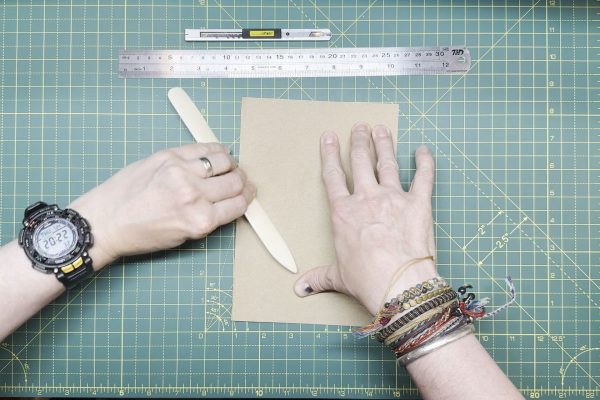 Using a bone folder to get a crisp fold.
