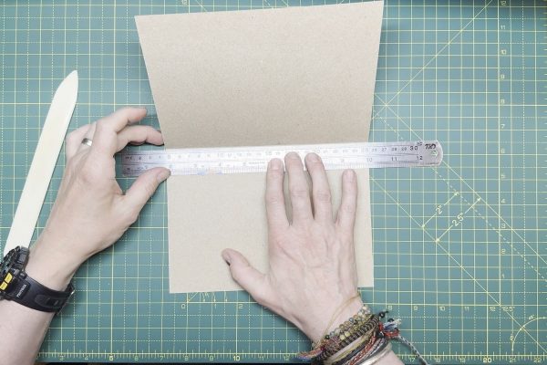 Lining the ruler along the crease of the card.
