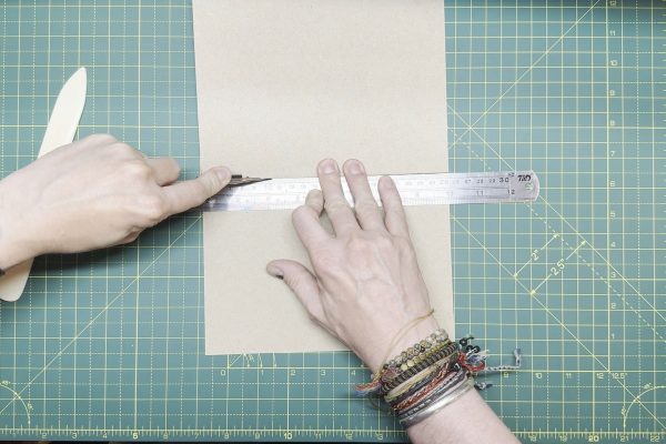 Cutting along the crease of the card.