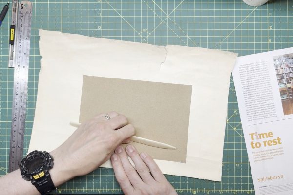 Using a bone folder to smooth out and remove any air bubbles.